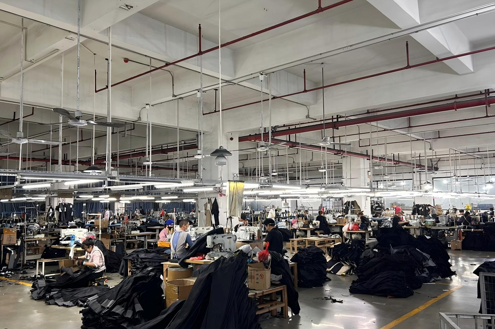 The rhythmic hum of sewing machines persists